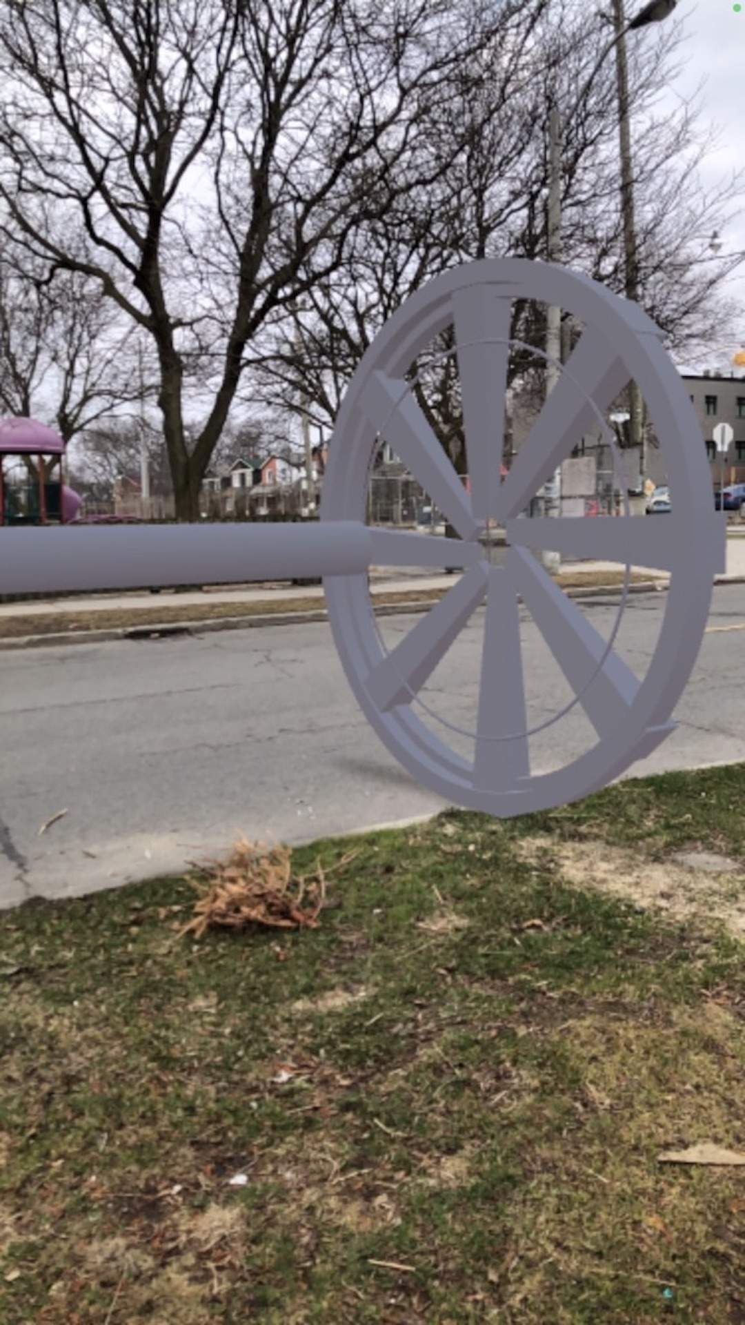 photo of a street with a 3D rendering of a large grey wheel